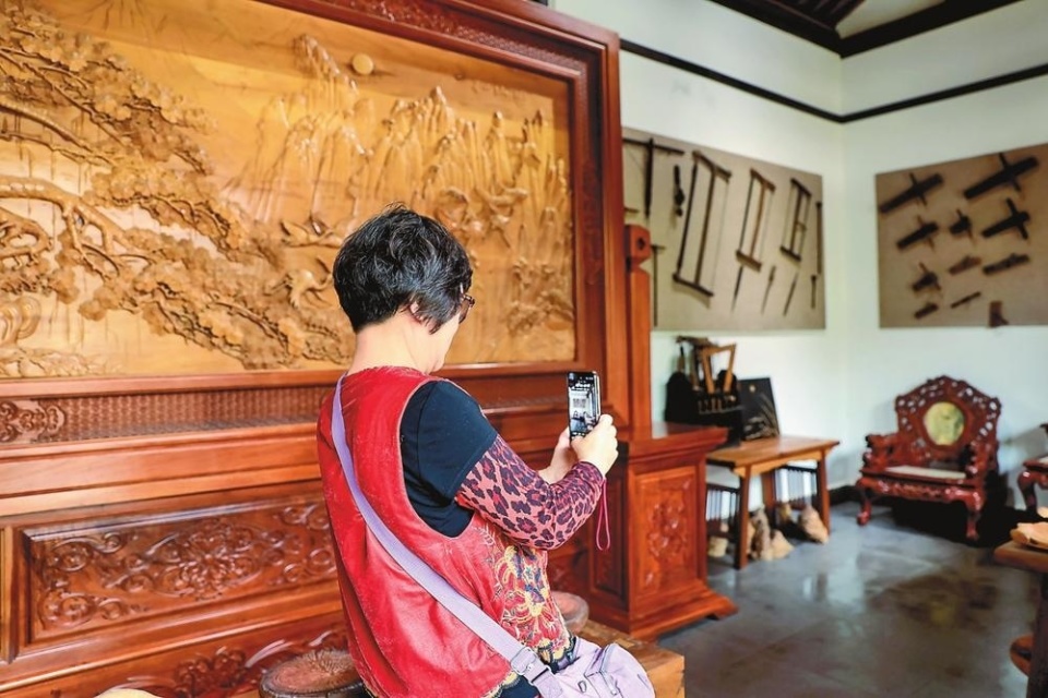 游客参观拍照木匠师傅雕刻木雕工艺品在素有木雕之乡之称的剑川县