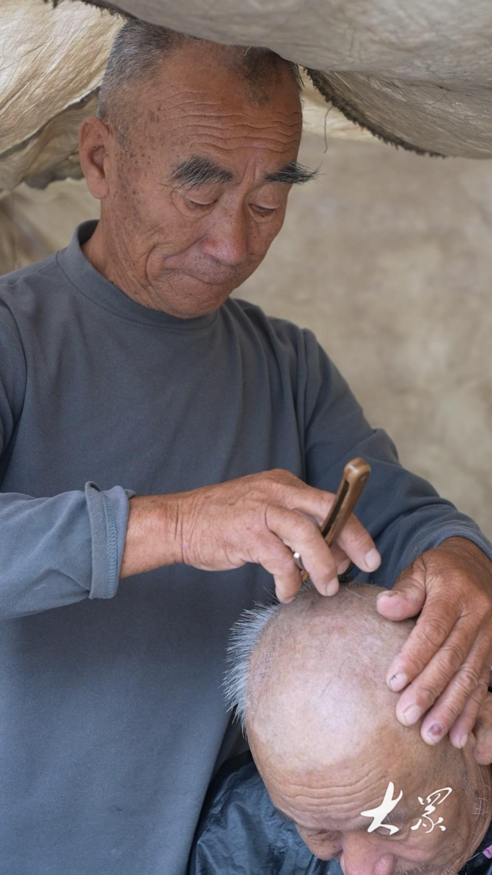 剪子,梳子……这是一位剃头匠的摊位,摊主手中握着一把锋利的剃刀为