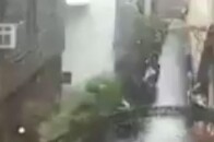 印度男子拉开暴雨冲刷后的大门 门缓缓连着墙体一起倒塌 多车被砸 所幸无人受伤_腾讯新闻